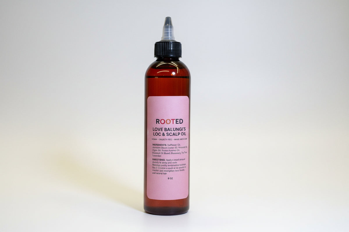 Bottle of Rooted hair care product with pink label on a yellow and white background